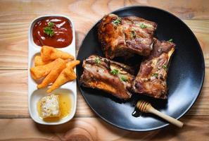 bbq pork ribs grilled with honey sweet sauce and herbs spices served on the table - Roasted barbecue pork spare rib sliced photo