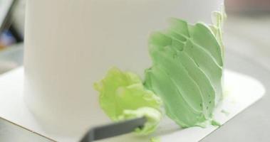 Close-up, Chef spreading pastel green cream around the butter cake. video