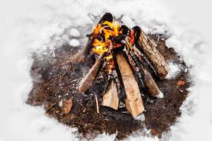 fogata arde en la nieve en el bosque .. fogata ardiendo en invierno frío. nieve, bosque y fuego. invierno. turismo. llamas en la nieve. fondo de invierno. naturaleza. foto