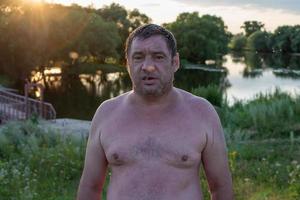 fat and wet man after swimming in the river , fat human body photo