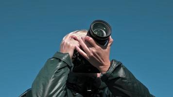 Una chica fotógrafa toma fotografías del cielo azul con una cámara. foto