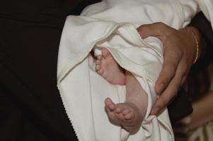 Las piernas del bebé en la iglesia en la ceremonia del bautismo. religión. de cerca.