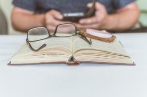 man reading a book at the table, having a snack while reading, a short break photo