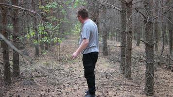 Un hombre solitario con gafas camina por un bosque oscuro. foto