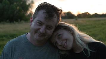 dad and adult daughter hug against the background of autumn nature at sunset photo