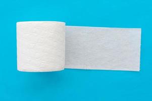 Roll of white toilet paper on a blue background. Close up. photo