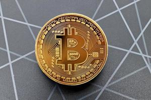 Golden Bitcoin isolated on geometric background. New technological economy concept. photo