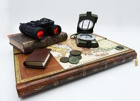 Set of items for adventure and exploration. Books, map, compass, old coin isolated on white background. photo