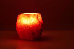 Natural salt stone lamp isolated on red warm background photo