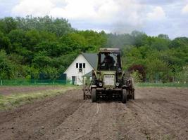Plowed field by tractor in brown soil on open countryside nature photo