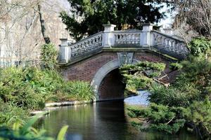 Beautiful old stone bridge with railing over clean river in preserve