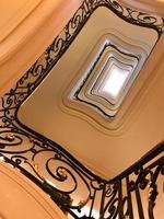 Ver de abajo hacia arriba en una hermosa escalera de lujo con barandas de madera foto