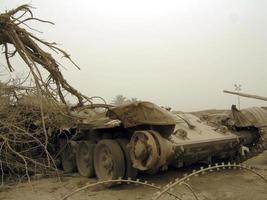 Tanque de vehículo del ejército militar en pistas con barril después de la guerra victoriosa foto