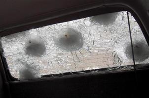 Gran grieta en el parabrisas del coche de un fragmento de bala de francotirador militar foto