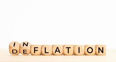 Inflation or deflation word in wooden blocks on table. Copy space photo