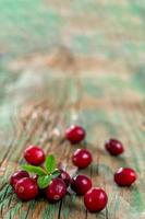 Fresh cranberries fruits on old green wooden Background and daylight