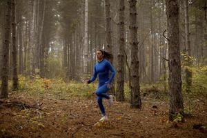 mujer joven, funcionamiento, en, el, pista forestal, en, otoño foto