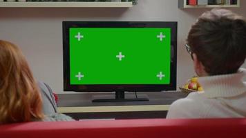 coppia che guarda la tv a schermo verde sullo sfondo di Natale. video