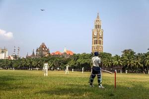 MUMBAI, INDIA, 2015 - Unidentified people playing sqiash by the Rajabai Clock Tower in Mumbai. Tower was completed at 1878 and have height of 85 m.