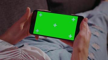 kvinna hemma avkopplande läsning på smartphone med grön skärm video