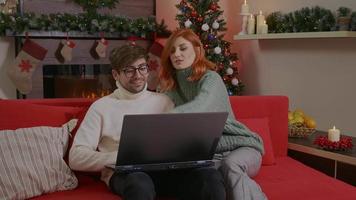 Happy couple choose online Christmas gifts on internet. video