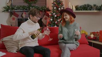 Couple having a romantic evening pour wine into glasses Christmas time. video