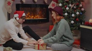 un couple heureux enveloppe des coffrets cadeaux de Noël pour la famille et les amis. video