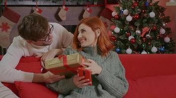 Happy man is making christmas gift to his beloved woman. video