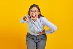 Portrait of young business woman laughing heartily at funny crazy joke with hands on body photo