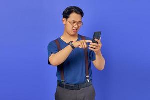 Confused young man on how to use mobile phone to open social media with blank space over purple background photo