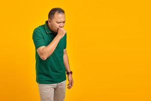 Portrait of Handsome Man feeling unwell and coughing on yellow background photo