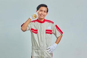 Portrait of smilling handsome man wearing mechanical uniform pointing at head with finger and good idea over gray background photo