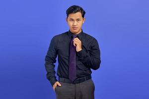 Smiling young handsome businessman with a confident face on purple background photo