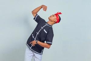 Image of handsome sportsman dressed in kimono practice in karate isolated over grey background. looking up photo