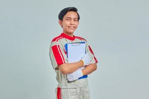 Portrait of smiling mechanic man showing clipboard on gray background photo