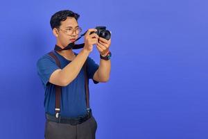 Handsome photographer taking photo on purple background