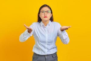 Photo of shocked young business woman with confused and displeased expression on yellow background