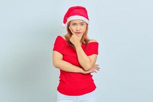 retrato, de, joven, mujer asiática, llevando, pensativo, vestido de navidad, pensamiento, pregunta, con, dedo, mentón, encima, fondo blanco foto