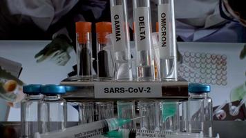 Los tubos de ensayo sars cov 2 etiquetados con variantes alfa gamma delta beta y omicron se retiran del bastidor en el laboratorio de trabajo. video