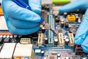 technician repairing inside of hard disk by soldering iron. Integrated Circuit. the concept of data, hardware, technician and technology. photo