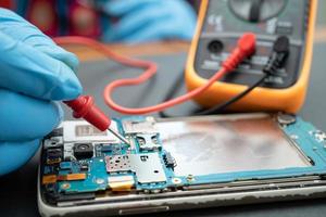 Technician repairing inside of mobile phone by soldering iron. Integrated Circuit. the concept of data, hardware, technology. photo