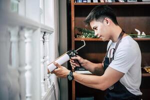 The carpenter holds the glue and attaches to the window. photo