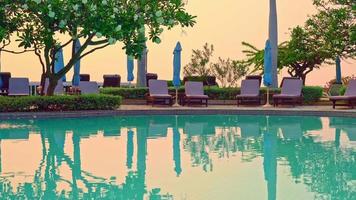 sedia piscina intorno alla piscina con sfondo oceano mare - vacanze e concetto di vacanza