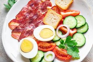 desayuno inglés tocino, huevo, tomate, pepino, pan tostado