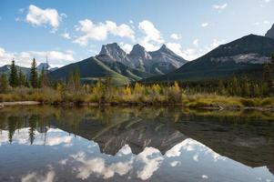 El paisaje de las montañas de las tres hermanas, la reflexión sobre el río Bow en el bosque de otoño foto