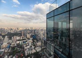 Modern glass building with crowded downtown at bangkok city