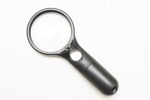 A black magnifying glass with an optical magnifier on a white background photo