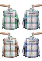 Children hand holding checkered boy shirt on white background photo