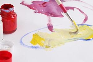 Asian boy use paintbrush and watercolor painting in paper photo