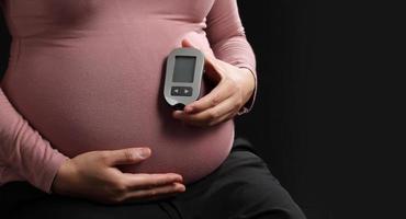 Pregnant woman holding blood sugar level meter, Pregnancy health